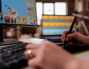 Close up of female designer using stylus on graphic tablet