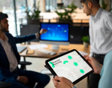 Hands holding a tablet against the background of men with a graph