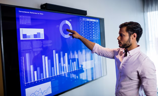 A man presses a touch screen with a graph